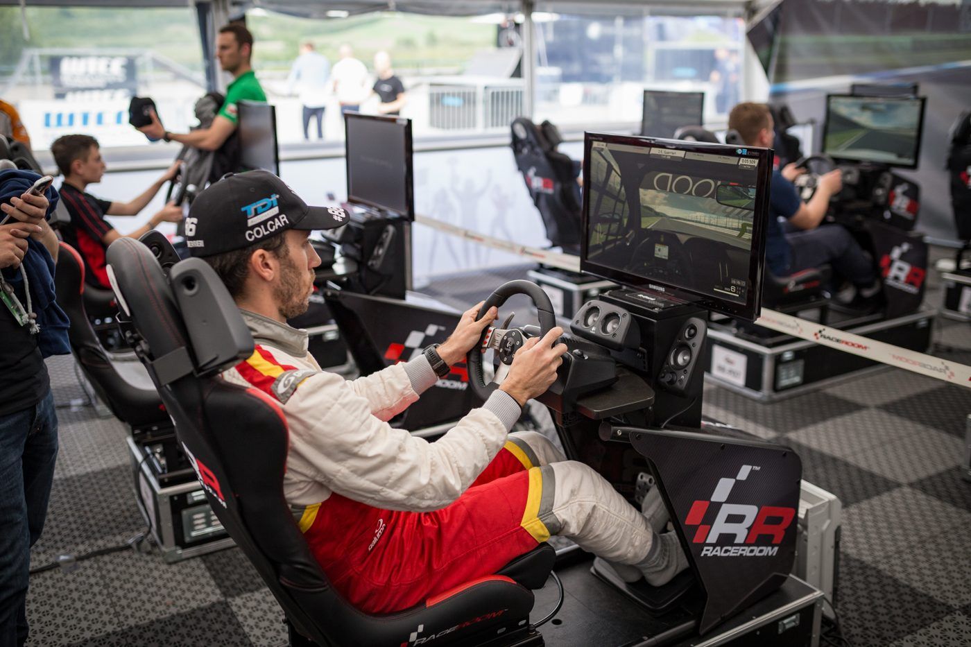 Pilote de sim racing au volant devant un écran, dans un baquet de simulation
