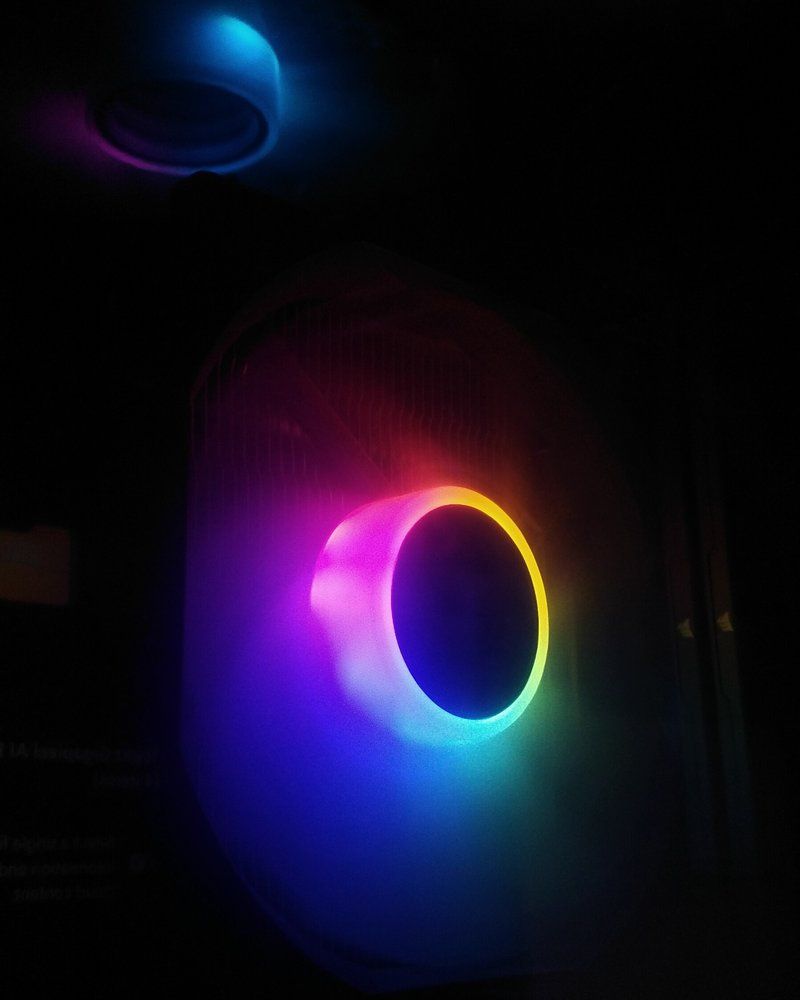 Ventilateurs RGB allumés dans un boîtier de PC, dans le noir