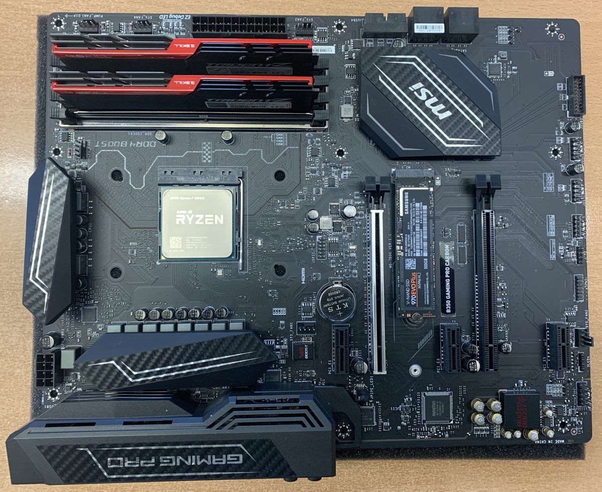 Carte mère de PC avec un SSD NVMe installé dans son slot M.2 entre les ports PCIe