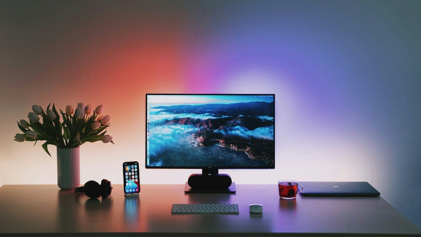 Bureau minimaliste avec grand écran large, clavier et lumière ambiante